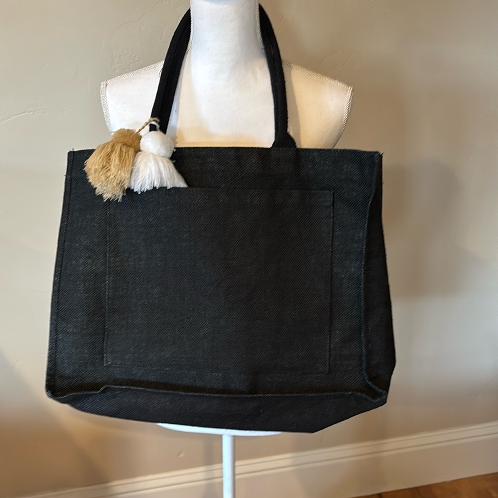 Mud Pie brand bag with side pocket and tassels.